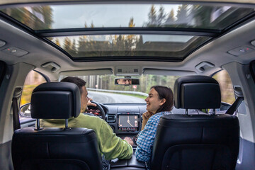 Man and woman traveling in car, sitting in car driving to travel destination.