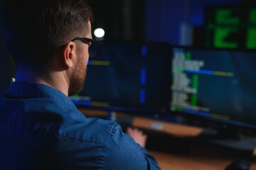 Night Office: Young Handsome Man in Working on Desktop Computer. Digital Entrepreneur Typing Code