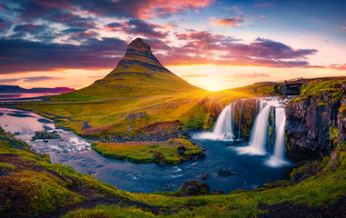 Majestic summer sunset on famous Kirkjufellsfoss Waterfall with Kirkjufell peak on background....
