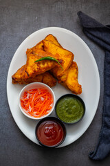 Selective Focus of Bread pakora is a popular Indian street food made with bread, stuffed with spicy potato filling, coated in chickpea flour, and deep-fried.