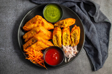 Selective Focus of Bread pakora is a popular Indian street food made with bread, stuffed with spicy potato filling, coated in chickpea flour, and deep-fried.
