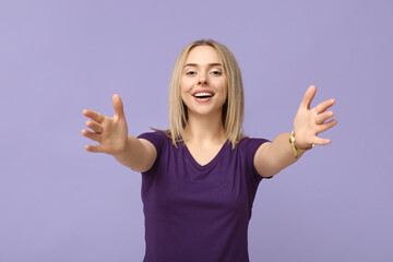 Young woman opening arms for hug on lilac background