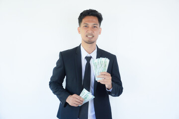 Adult Asian man wearing black suit and tie holding paper money while showing happy face expression
