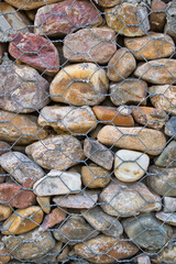 Wall of stones held with metal mesh.
