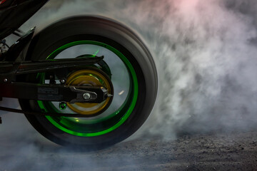 Motorbike burning tire rubber with white smoke for race, Motorbike burning tire rubber, Motorbike burns wheel on race track.