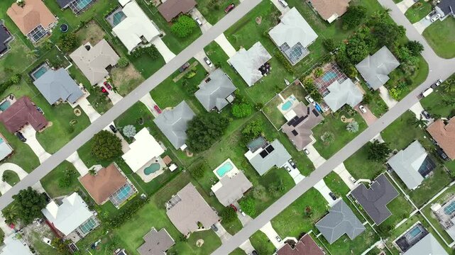 Noble Suburban neighborhood in Florida. Green neat garden with swimming pools. Quiet community layout with spacious yards and well-kept homes. Luxury Villas in american Town. Aerial top down flyover.