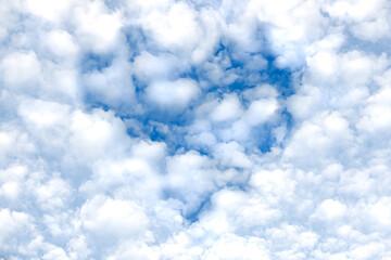 White clouds and blue sky in the shape of a heart in the center of the photo.