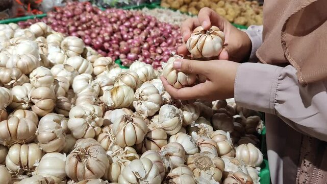 Woman's hand buying garlic at the market