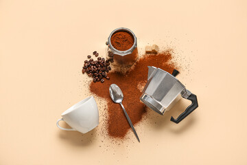 Geyser coffee maker with beans, cup and spoon on beige background