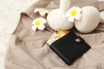 Composition with spa herbal massage bags, wallet, flowers and massage therapist uniform on light...