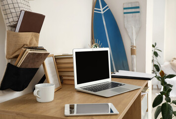 Laptop with books on table in teenager's room, closeup