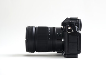 Black digital mirrorless camera with blank LCD and buttons. Side view, isolated on a white background. Full depth of field.