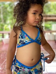 Portrait of a cute Asian little girl in blue swimsuit