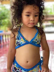 Portrait of a cute Asian little girl in blue swimsuit