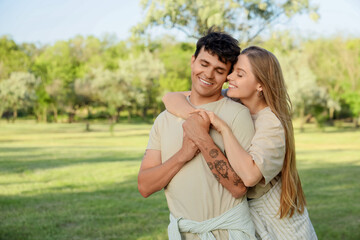 Fototapeta premium Beautiful young happy couple hugging in summer park