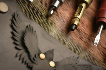 Leather craft work tools and leather on the tanner workbench concept background.