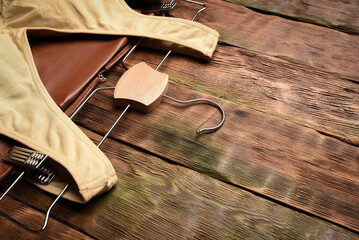 Female tank top and brown leather skirt on the wooden shop counter background.