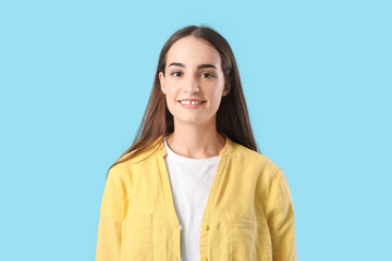 Portrait of beautiful young happy woman on blue background