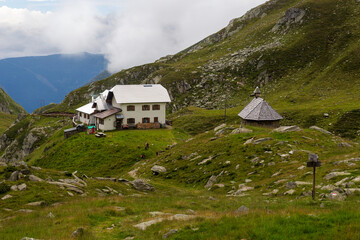 Alpine hut Lodnerhütte (Rifugio Cima Fiammante) in the mountains and Flock of goats (Passeirer...