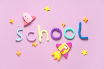 Rockets made of plasticine with word SCHOOL on pink background. Top view