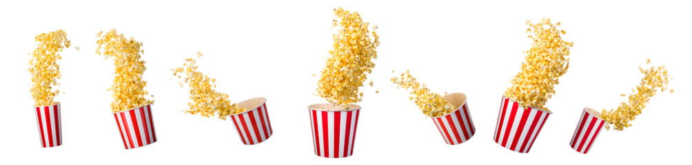 Flying popcorn from paper striped bucket isolated on black background