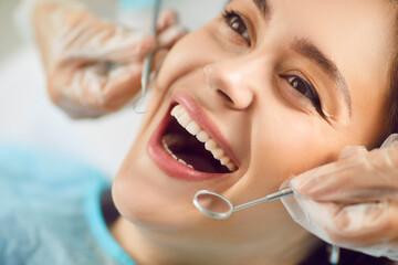 Close-up portrait of female patient with open mouth in modern dentistry clinic during medical check...