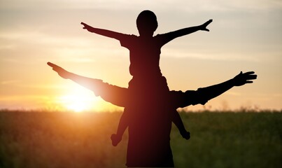 father and son play together in park