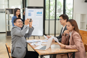 Asian business presents to explain the graph work on the whiteboard. Consulting, discussing, exchanging knowledge.