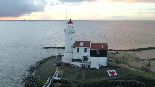 Aerial view of sunrise over Paard van Marken lighthouse and lake coast, Marken, Netherlands.