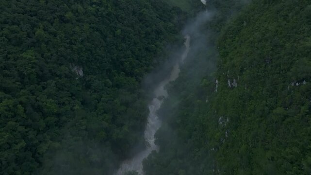 Aerial view of misty river flowing through lush forest in Semuc Champey, Alta Verapaz, Guatemala.