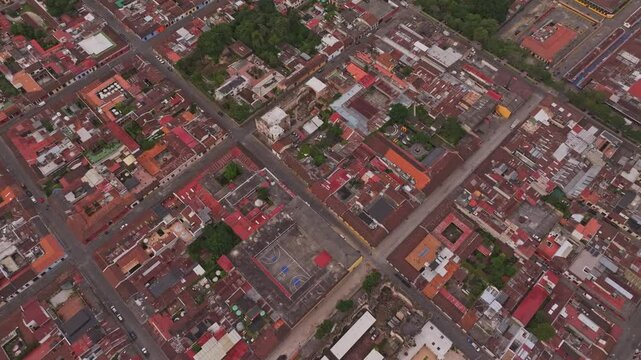 Aerial view of colorful colonial city with vibrant rooftops and dense greenery, Antigua, Guatemala.