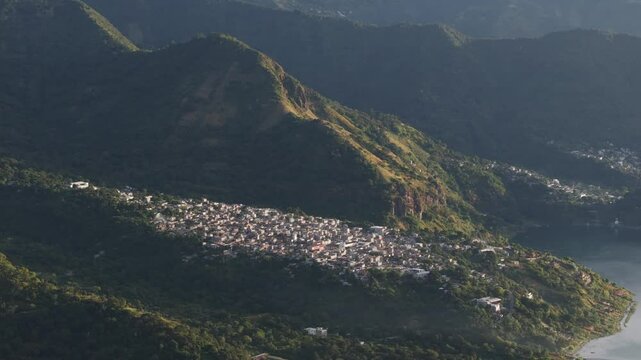 Aerial view of tranquil village, majestic mountains, serene lake, and city with volcano, San Marcos La Laguna, Solola, Guatemala.