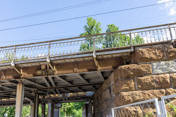 A bridge with a railing and a stone wall on the side