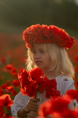 A young girl wearing a red flower crown is standing in a field of red poppies. Concept of innocence...