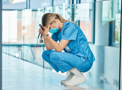 Hospital, doctor and woman on floor with stress for burnout, mistake or surgery fail in corridor. Tired, healthcare and sad physician with face mask in clinic for fatigue, medical crisis or loss