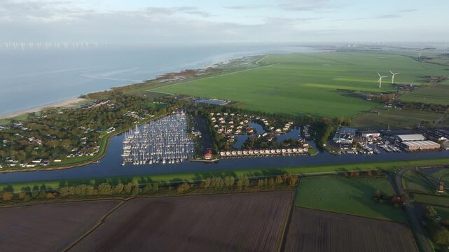 Aerial view of tranquil coastal town with wind turbines and marina, Workum, Friesland, Netherlands.