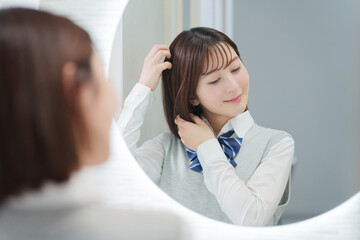 Fototapeta premium ヘアセットをする女子高生（ヘアケア・美容）