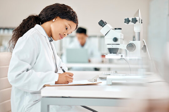 Science, woman and writing with microscope in laboratory for observation, research and biology experiment for study. Girl, clipboard and clinical analysis for disease diagnosis and healthcare.
