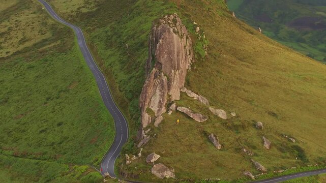 Aerial view of rocky road and lush hills at sunrise, rocha dos frades, flores, portugal.