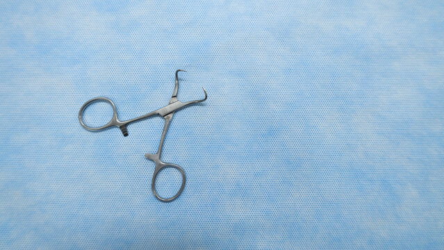 Stainless medical towel clamps placed on blue background.Towel clamps are mounting clamps with a pointed end to hold the ends of the towel or doek in place. Medical instrumets used in surgery.