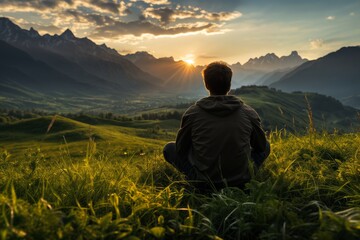 a man sits on the grass and looks at nature, a view of the hills and valley at sunset, a beautiful landscape, the concept of rest and relaxation
