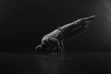 Male fighter training capoeira on black background