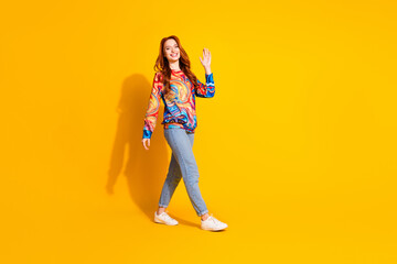 Photo of cheerful friendly adorable girl wear trendy print clothes hello sign isolated on vivid yellow color background