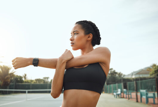 Outdoor, fitness and woman with stretching arm for morning exercise, thinking or workout routine. Sport, athlete and female person in thought for match, preparing or warm up muscles on tennis court