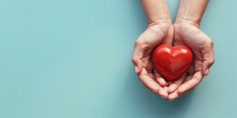 Pair of hands holding a vibrant red heart against a tranquil blue background, signifying love and care, Healthcare, Heart Health, Insurance and donation concept
