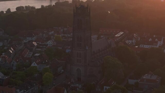 Aerial view of Sint-Maartenskerk, bridge, vessel, and city at sunrise over Waal River, Zaltbommel, Netherlands.