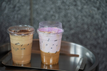 Close up glass of ice coffee with taro milk and ice cappucino  on raw cement table of a coffee shop summer terrace, menu photography.
