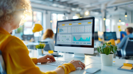 Woman Analyzing Data on Computer Screen in Modern Office