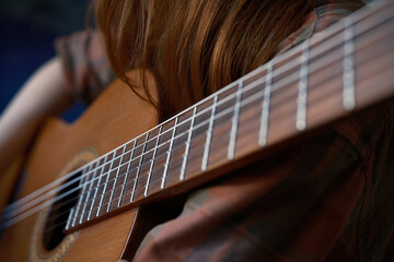 Cinematic shot close-up detail classic guitar and red girl  learning to play guitar  Music color
