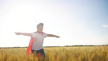 Superhero running through the wheat with his child. Hero super costume concept. girl runs across a field of wheat with a superhero. Girl runs through a field of fun wheat and runs into a superhero.